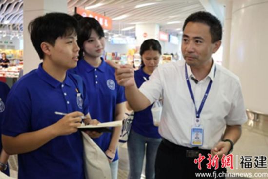 图为五通码头负责人(右一)向成员介绍金门乡亲服务站。 摄影 林佳